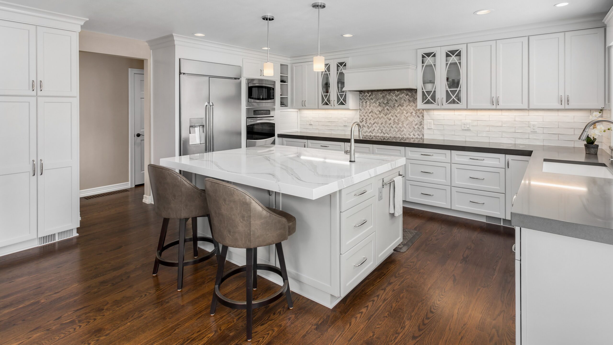 Modern kitchen in Waukesha County with beautiful hardwood floors, marble and metal countertops, and new cabinet refacing done by Colorwheel Painting